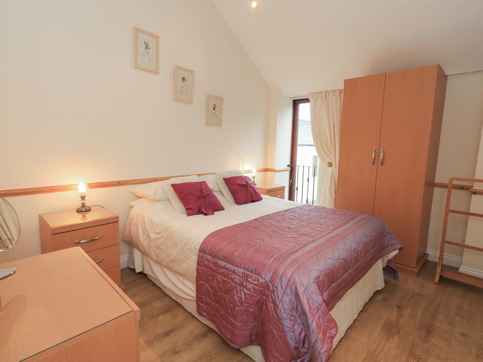 A bedroom with a bed and wardrobe at The Hayloft near Wigton