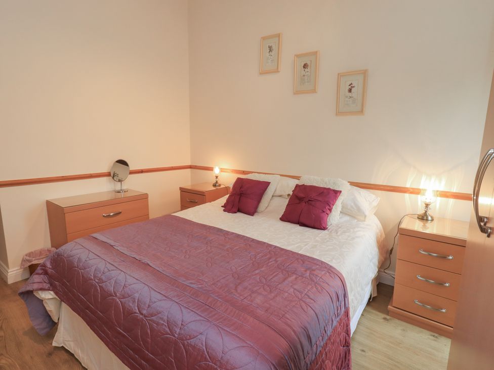 A bedroom with a bed and bedside tables at The Hayloft near Wigton