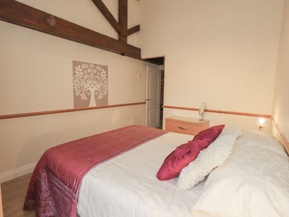 A bedroom with a bed and table at The Hayloft near Wigton