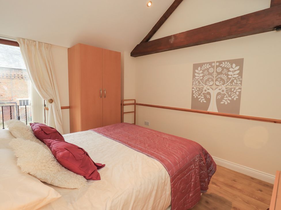 A bedroom with a bed and wardrobe at The Hayloft near Wigton