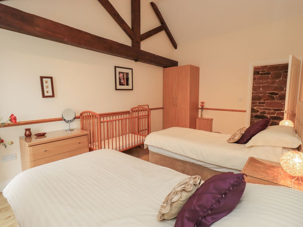 A bedroom with two beds and a cot at The Hayloft near Wigton