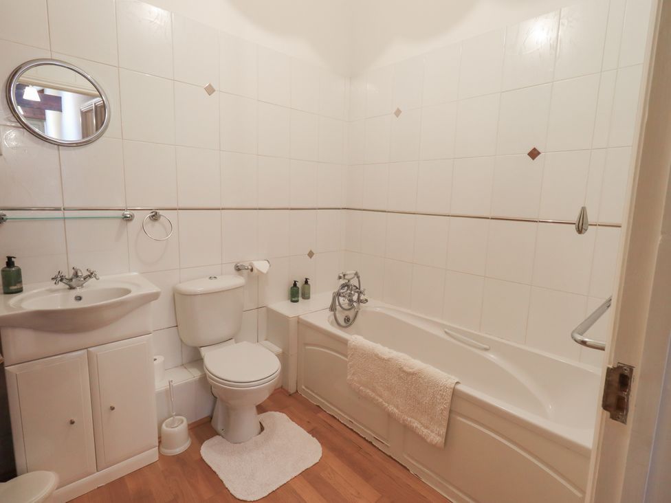 A bathroom with a bath tub, toilet, and sink at The Hayloft near Wigton