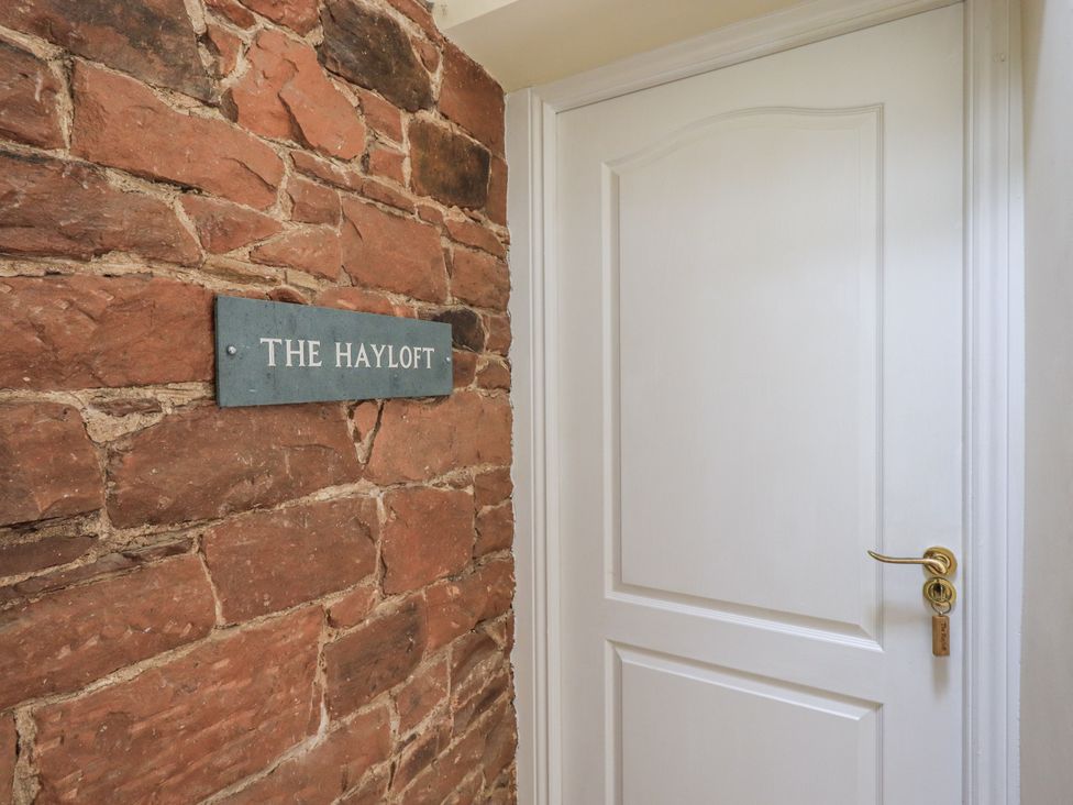 A hallway with a door and a sign at The Hayloft near Wigton
