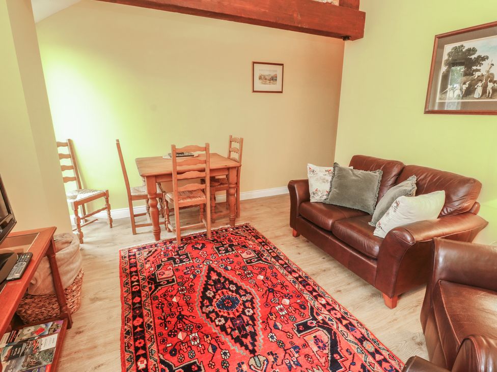 A living room with a table and chairs and a couch at The Hayloft near Wigton