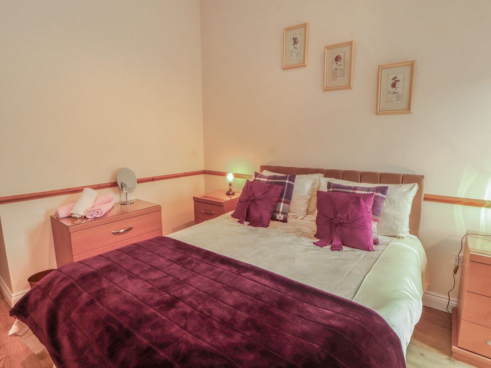 A bedroom with a bed and bedside tables at The Hayloft near Wigton