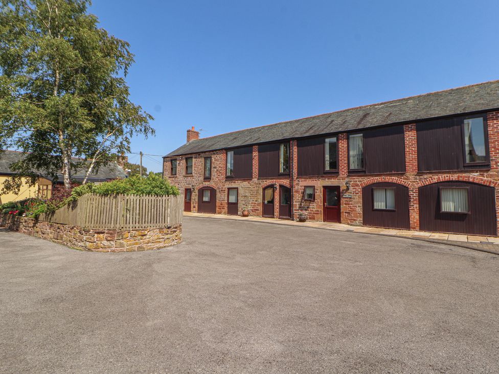 An outdoor view of a building with windows and a parking area at The Hayloft near Wigton