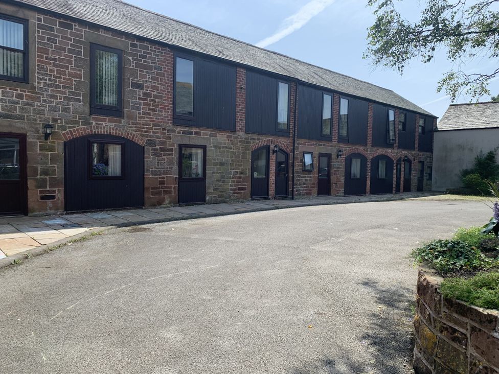 An exterior view of a building with multiple windows and doors at The Coach House near Wigton
