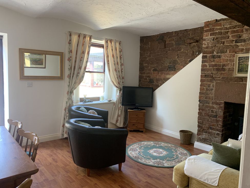 A living room with a sofa and television at The Coach House near Wigton