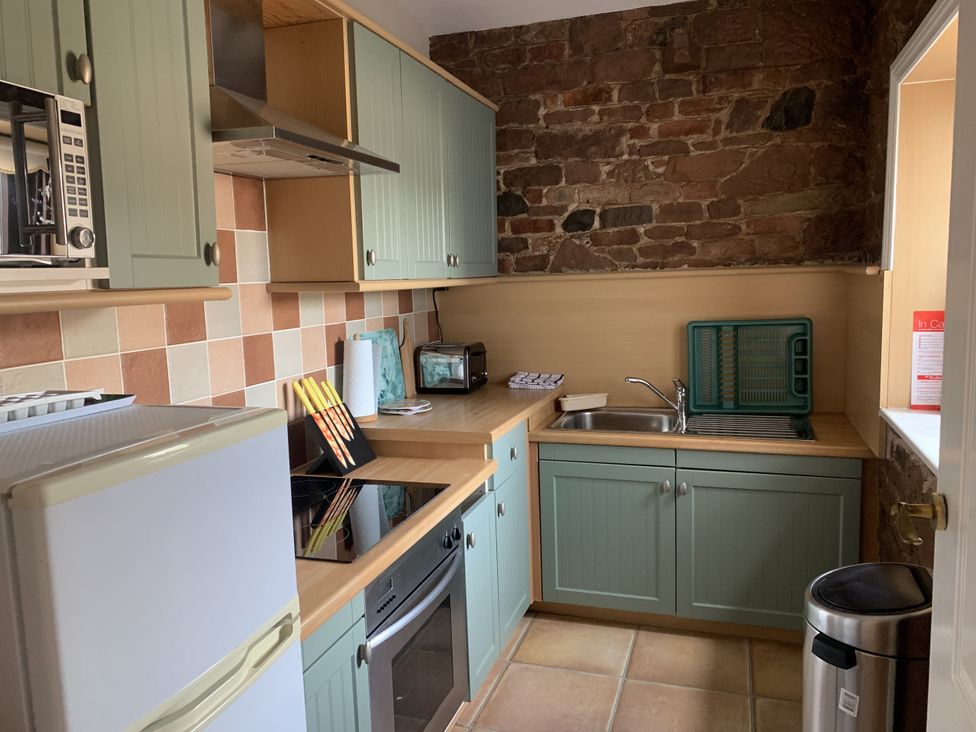 A kitchen with appliances and cabinets at The Coach House near Wigton