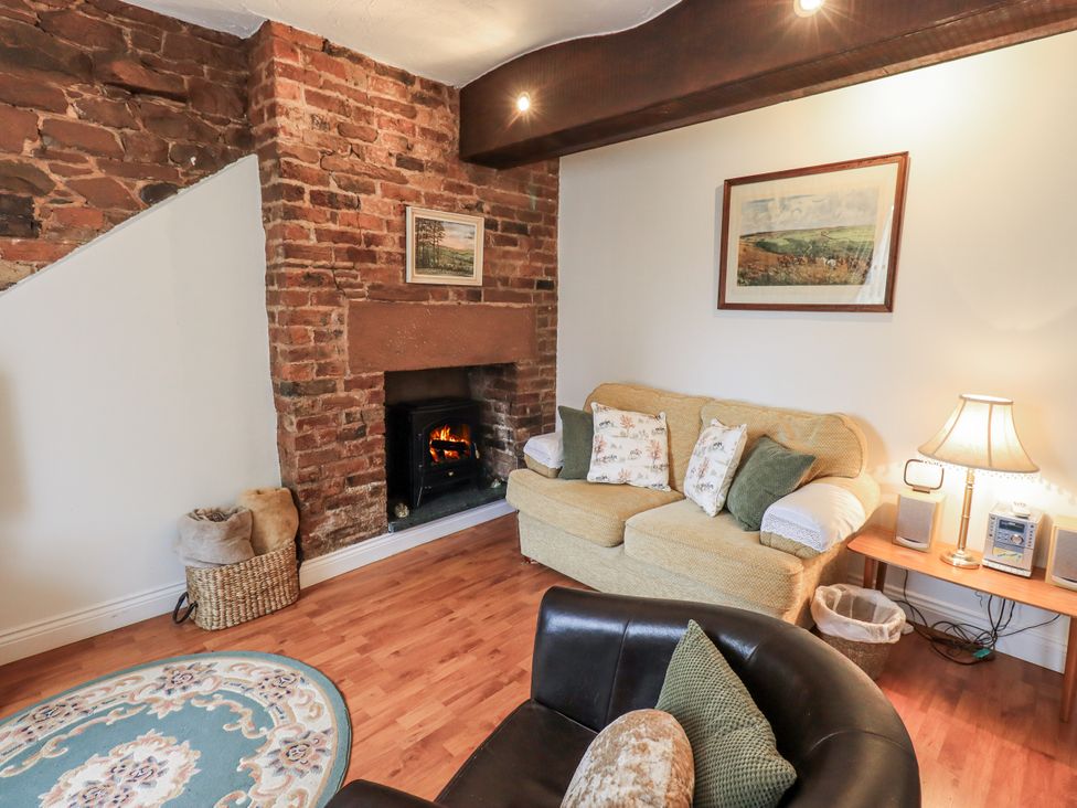 A living room with a sofa and a fireplace at The Coach House near Wigton