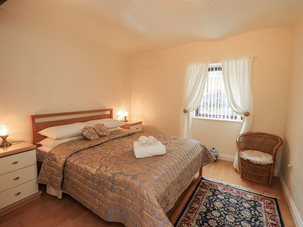 A bedroom with a bed and nightstands at The Coach House near Wigton