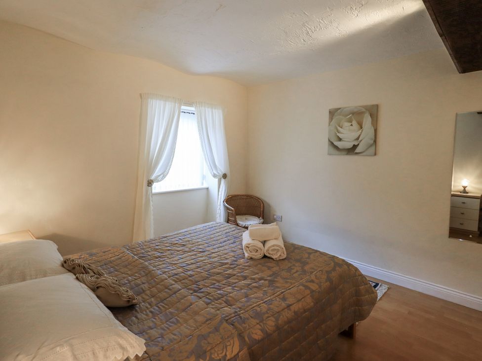 A bedroom with a bed and chair at The Coach House near Wigton