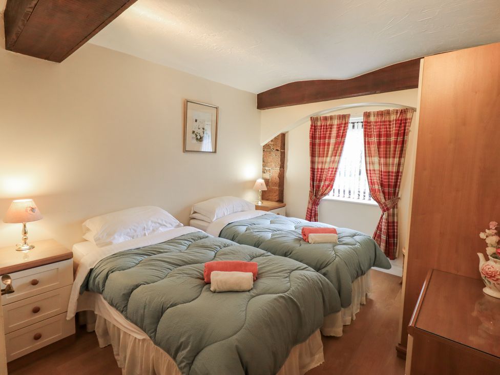 A bedroom with two beds and a lamp at The Coach House near Wigton