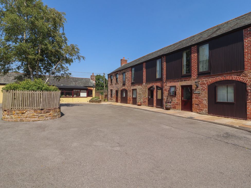 A view of houses and trees in a parking area at The Coach House near Wigton