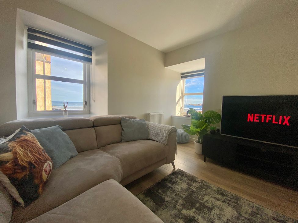 A living room with a sofa and television at 3 The Granary in Banff