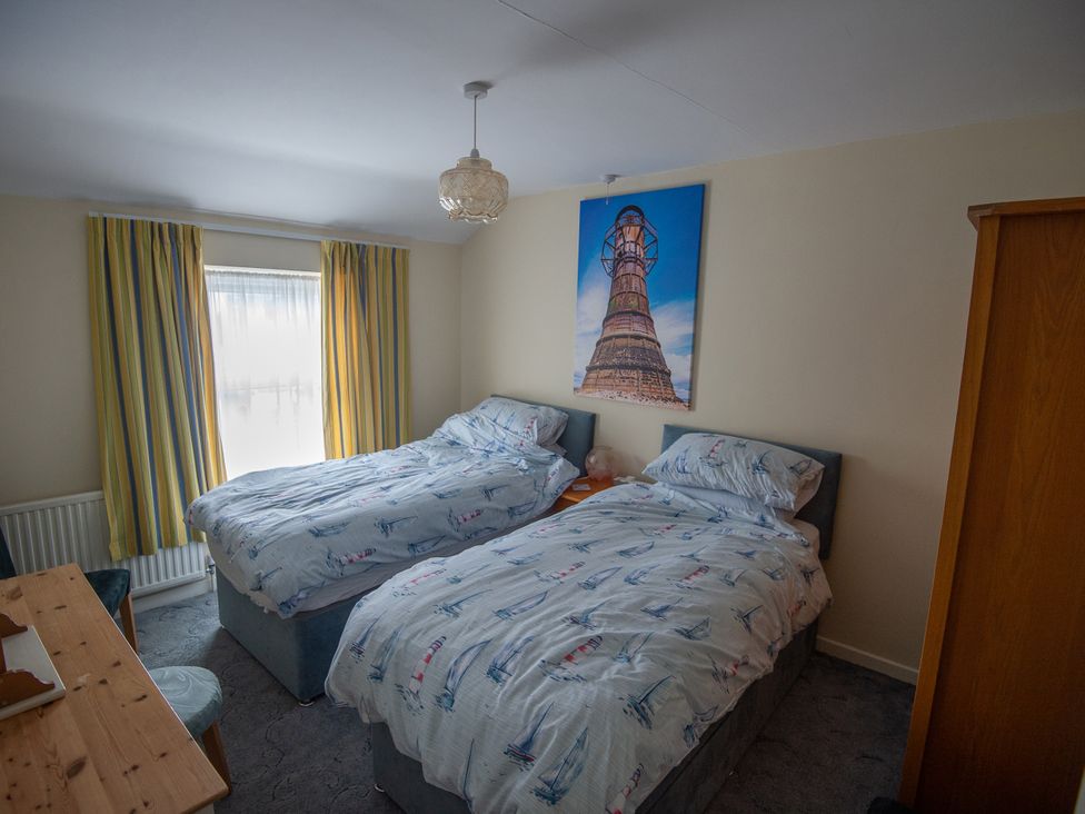 A bedroom with two beds and a window at 5 Bed Cottage Mumbles