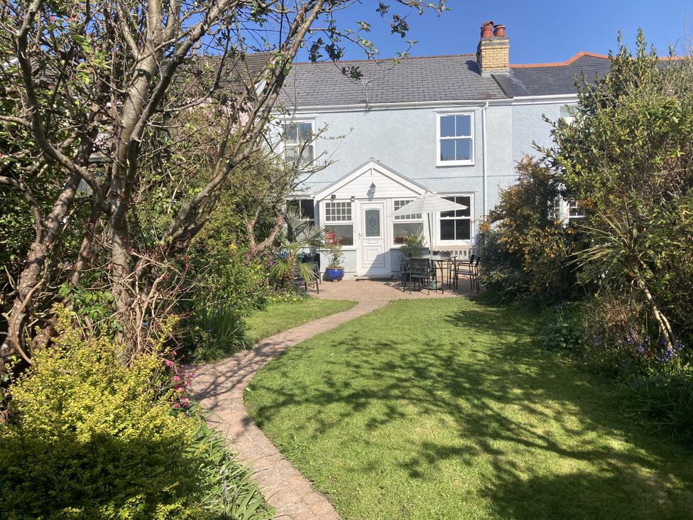A garden with a house and seating area at 5 Bed Cottage Mumbles in Mumbles