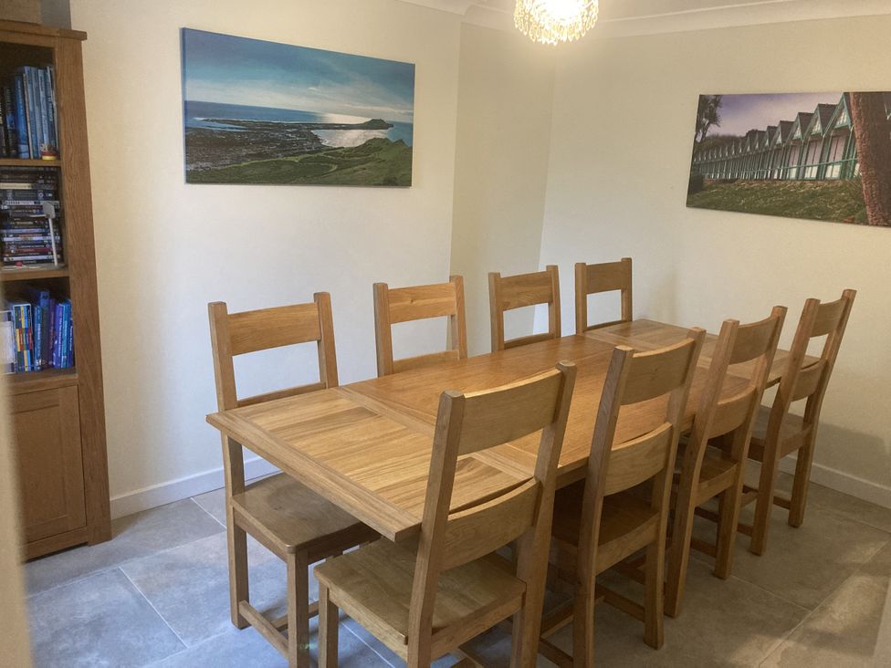 A dining room with a wooden table and chairs at Dunns Cottage in Mumbles