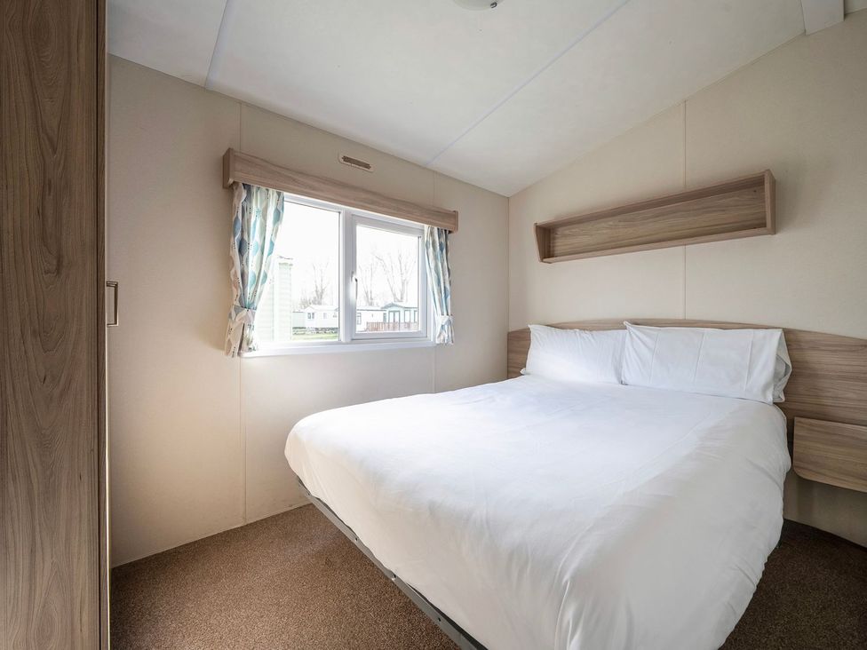 A bedroom with a bed and a window at Windsurfer’s Rest - Hayling Island