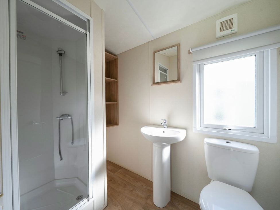 A bathroom with a shower, sink, and toilet at Windsurfer’s Rest - Hayling Island