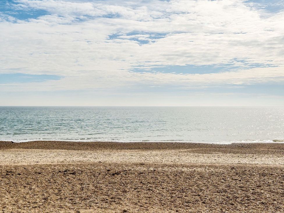 A beach with sand and sea under a cloudy sky at Windsurfer’s Rest - Hayling Island