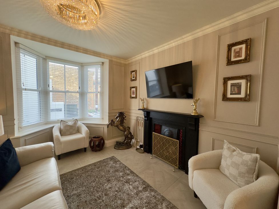 A living room with a television and fireplace at Ivy House in Conwy