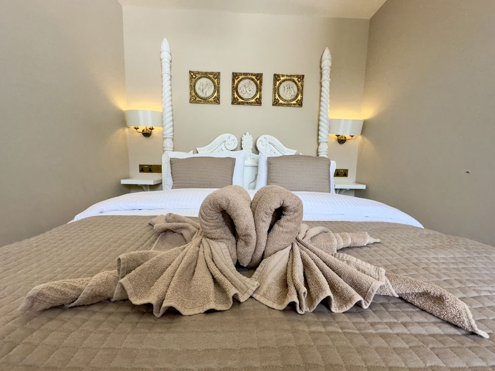 A bedroom with a towel swan on the bed at Ivy House in Conwy