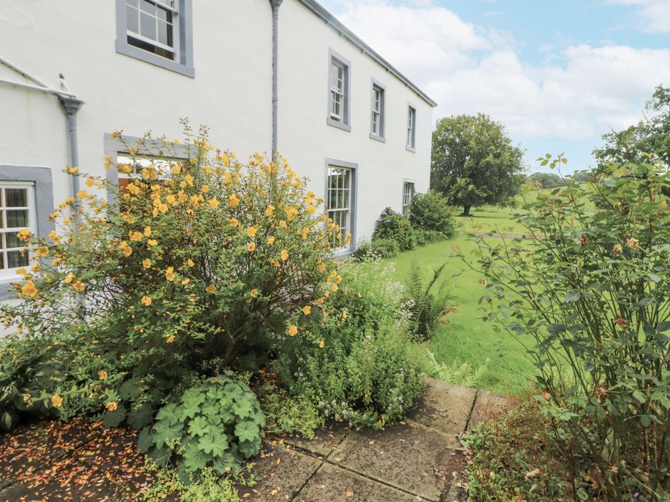 A garden with flowers and a house at Westward Park in Westward near Wigton