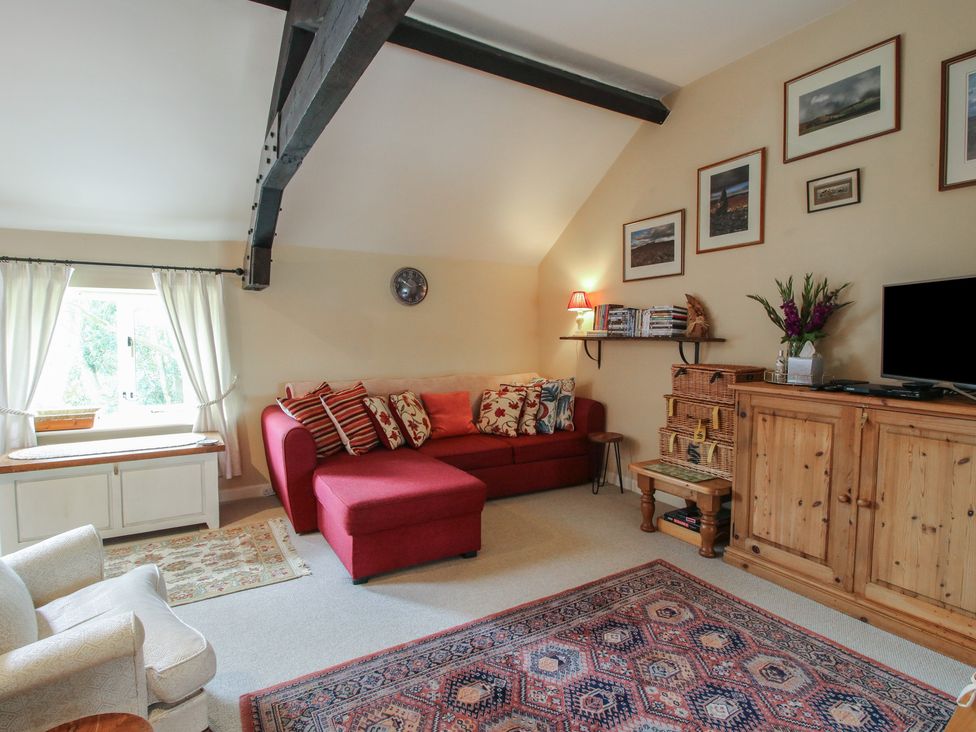 A living room with a sofa and television at Heribert Cottage in Shrewsbury