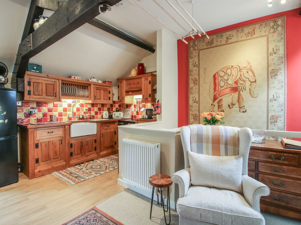 A kitchen with wooden cabinets and a single sink at Heribert Cottage in Shrewsbury