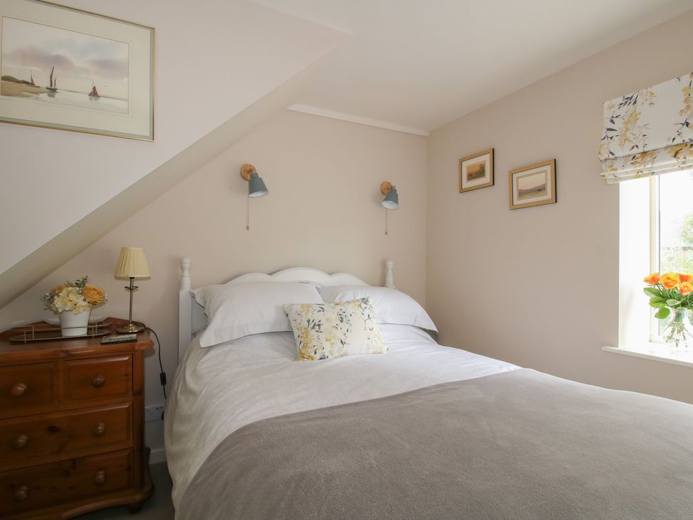 A bedroom with a bed and window at Heribert Cottage in Shrewsbury