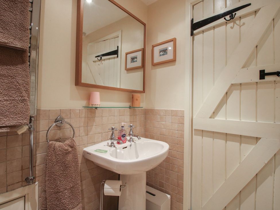 A bathroom with a sink and mirror at Heribert Cottage in Shrewsbury