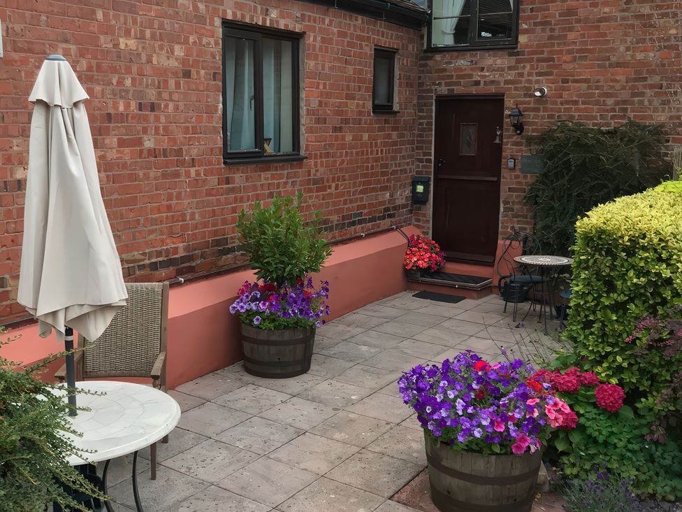 An outdoor area with flowers and seating at Heribert Cottage in Shrewsbury