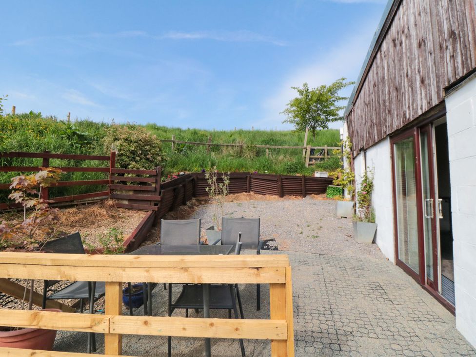 An outdoor patio area with chairs and plants at Grove Stables House in Yarm