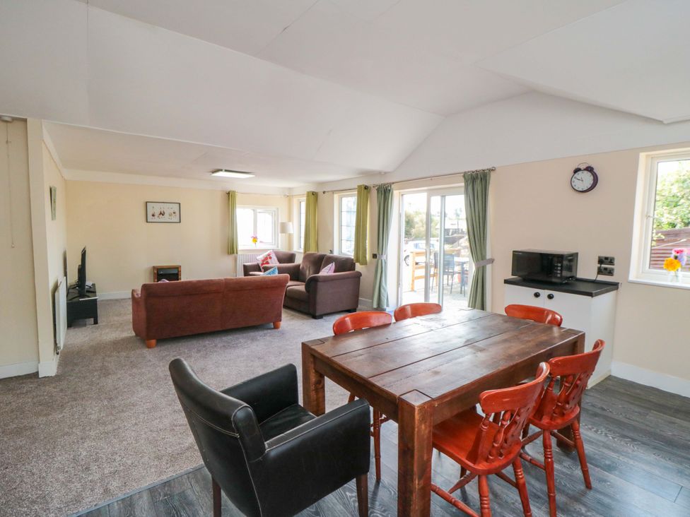 A living room with a dining area and sofa at Grove Stables House Yarm