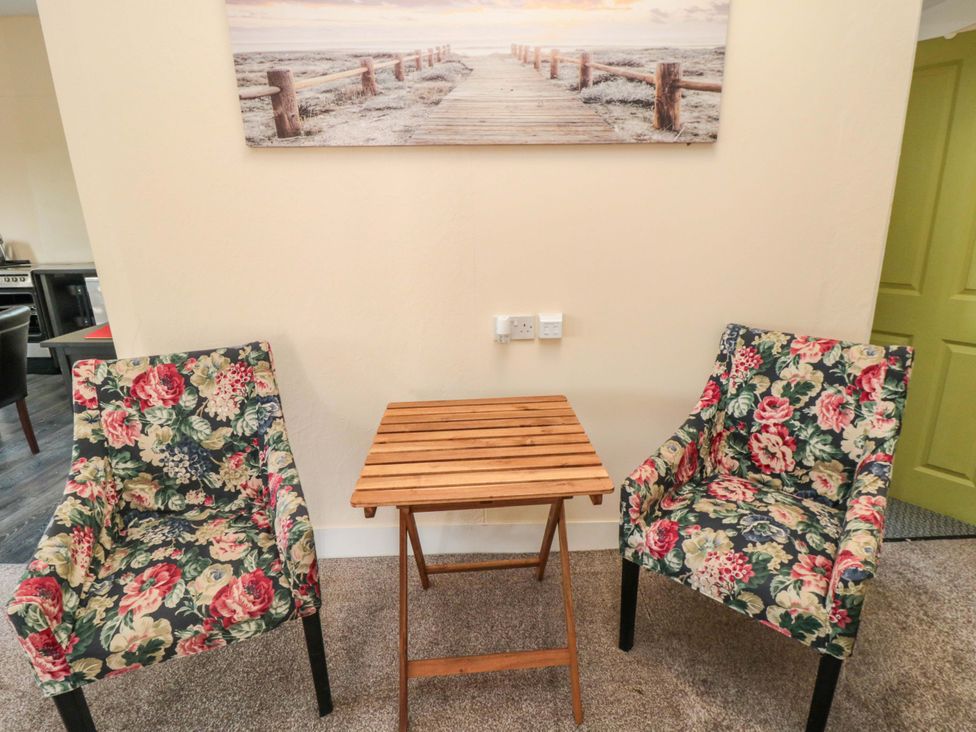 Two floral chairs and a wooden table in a sitting room at Grove Stables House Yarm