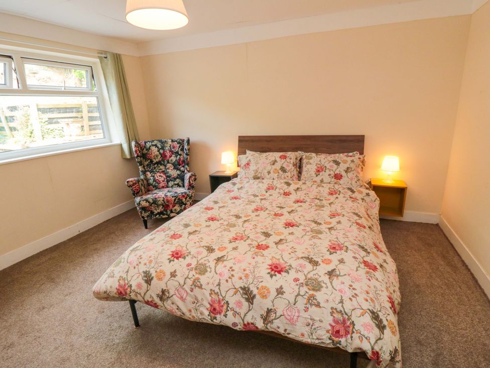 A bedroom with a bed and armchair at Grove Stables House in Yarm