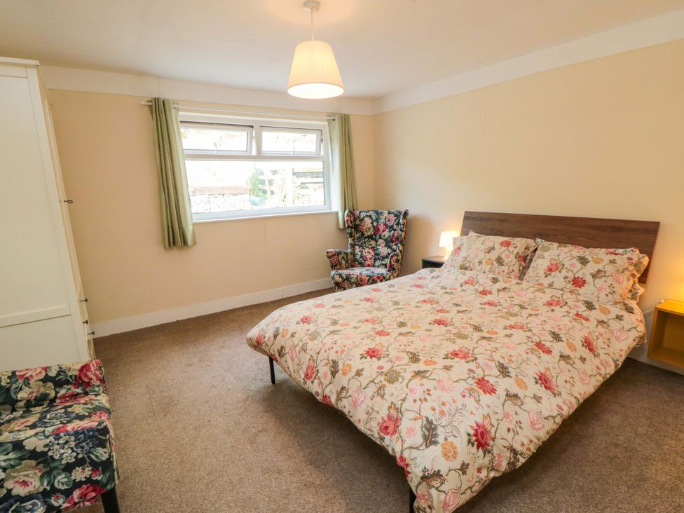 A bedroom with a bed and an armchair at Grove Stables House in Yarm