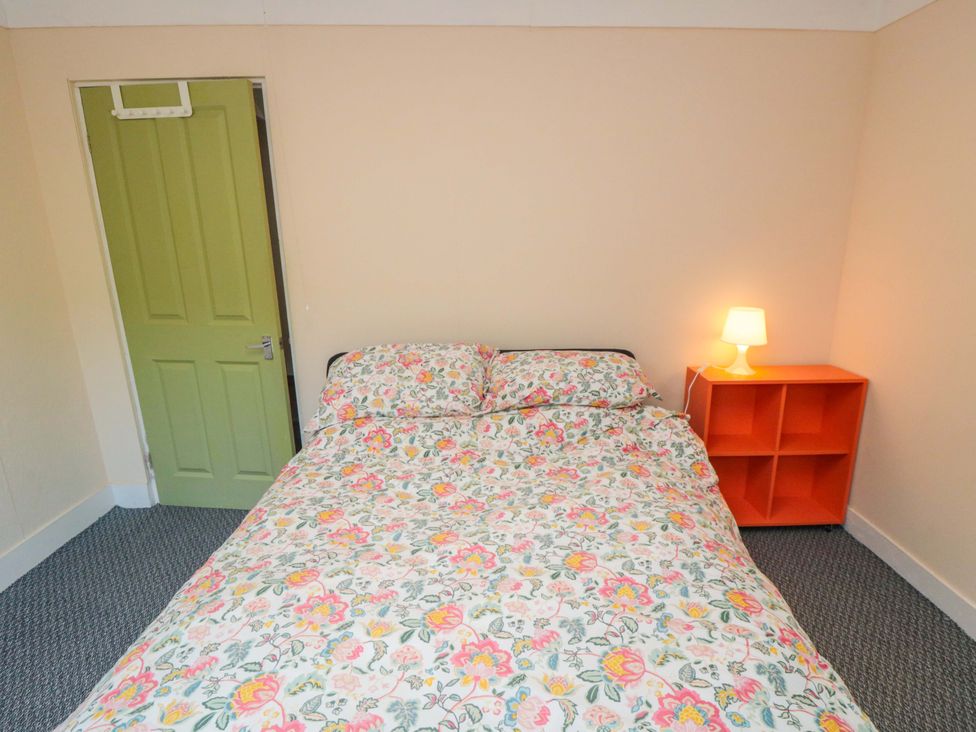 A bedroom with a bed and an orange shelf at Grove Stables House in Yarm