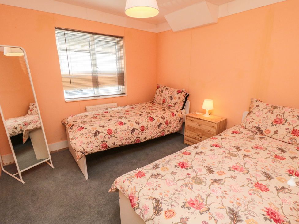 A bedroom with two beds and a mirror at Grove Stables House in Yarm