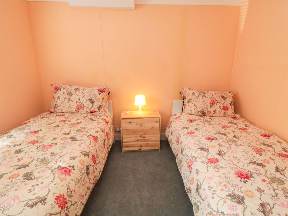 A bedroom with two beds and a lamp at Grove Stables House in Yarm