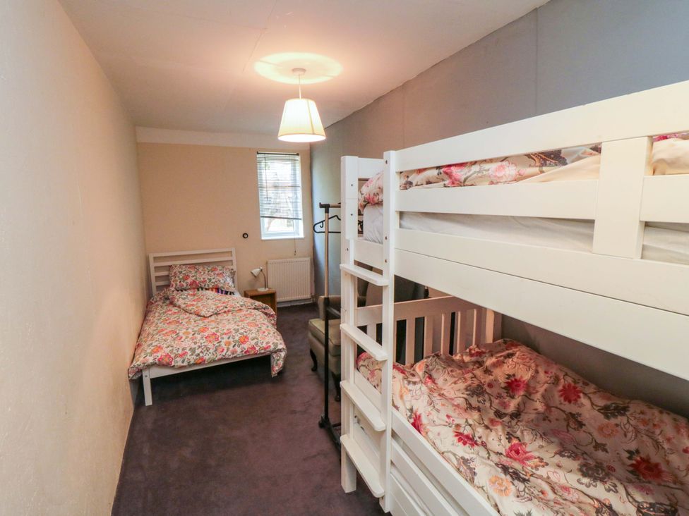 A bedroom with a bunk bed and a twin bed at Grove Stables House in Yarm