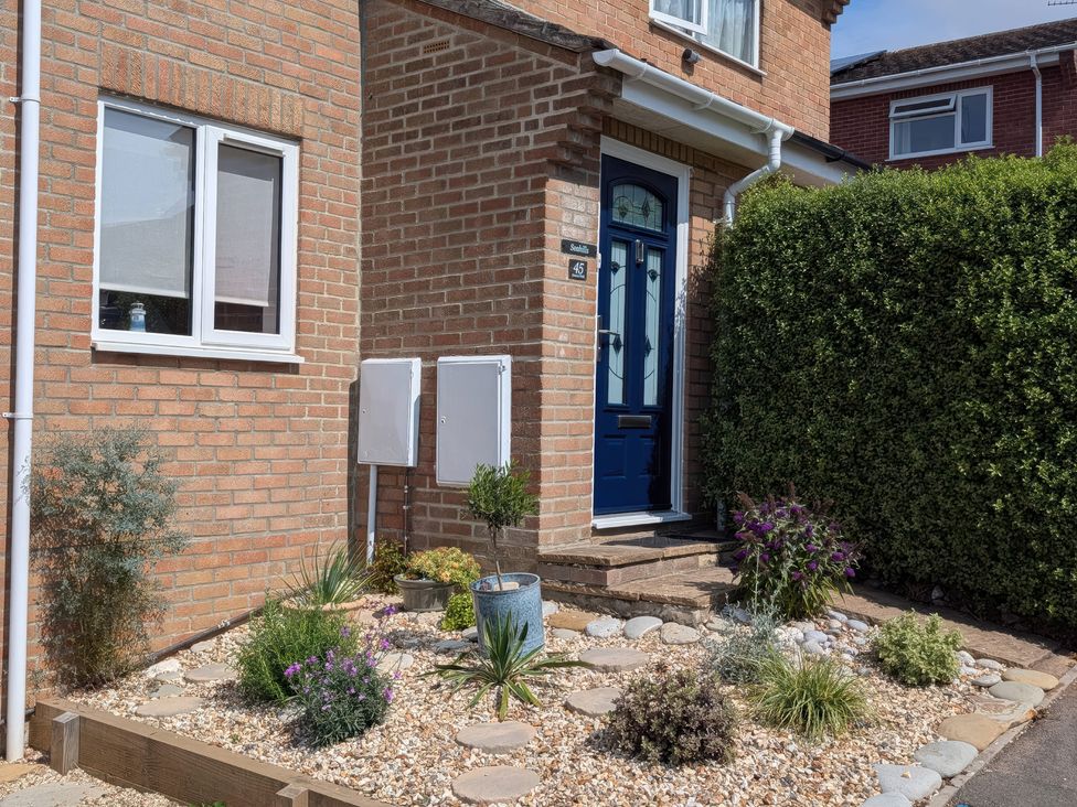 A front entrance with plants and a blue door at Seahills Lyme Regis
