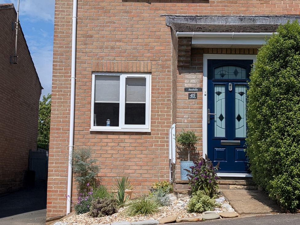 An outdoor view of a house exterior with a blue door at Seahills in Lyme Regis