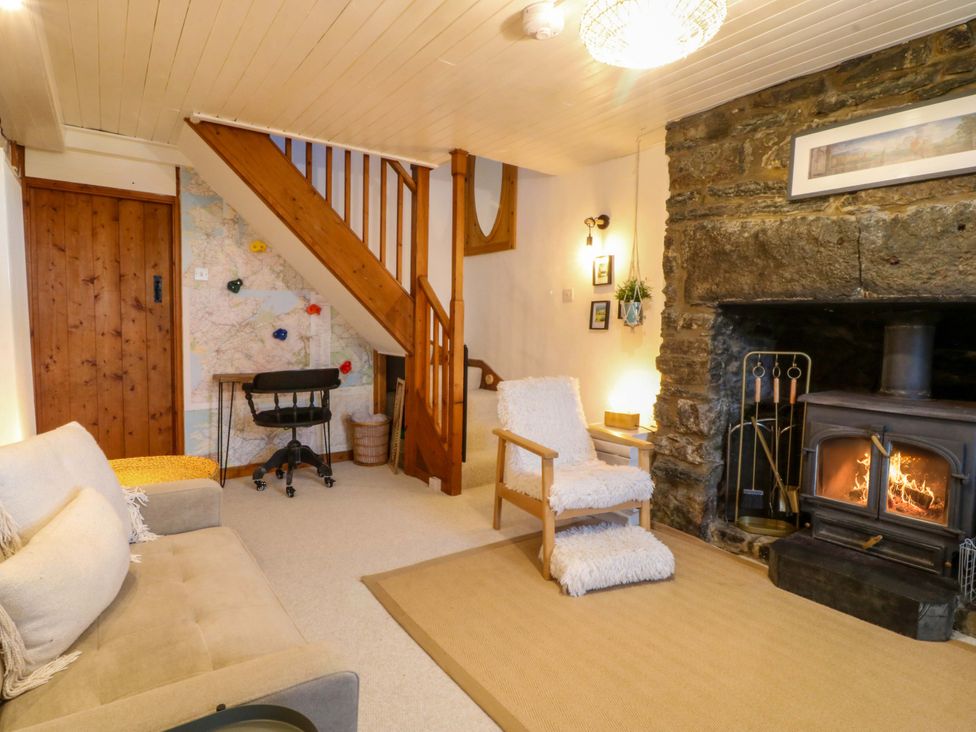 A living room with a fireplace and staircase at Waterfall Retreat in Blaenau Ffestiniog