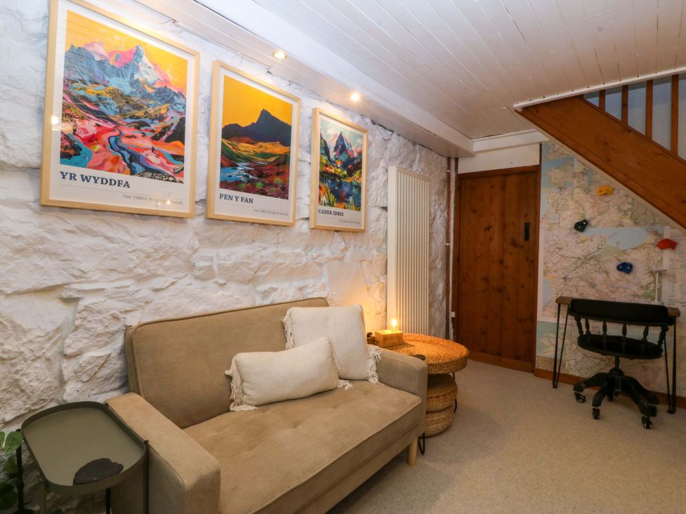 A snug with a sofa and posters on the wall at Waterfall Retreat in Blaenau Ffestiniog