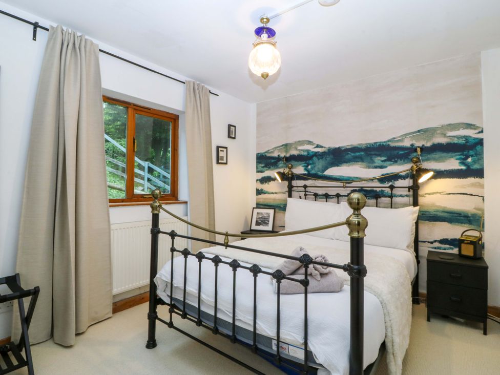 A bedroom with a bed and a nightstand at Waterfall Retreat in Blaenau Ffestiniog
