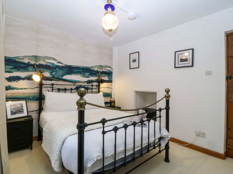 A bedroom with a bed and wall art at Waterfall Retreat in Blaenau Ffestiniog