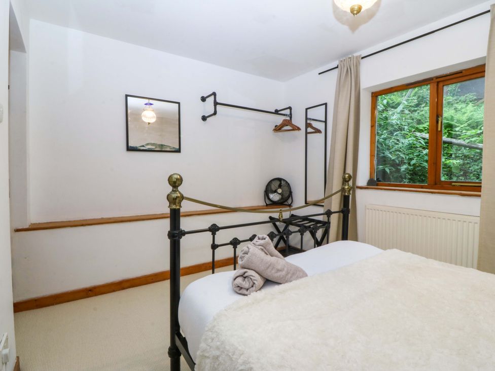 A bedroom with a bed and a clothes rail at Waterfall Retreat in Blaenau Ffestiniog