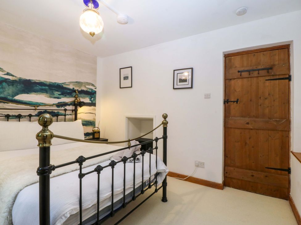 A bedroom with a bed and wooden door at Waterfall Retreat in Blaenau Ffestiniog